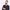 Reuben Kebede in a dark navy suit, holding his violin and looking off to the side